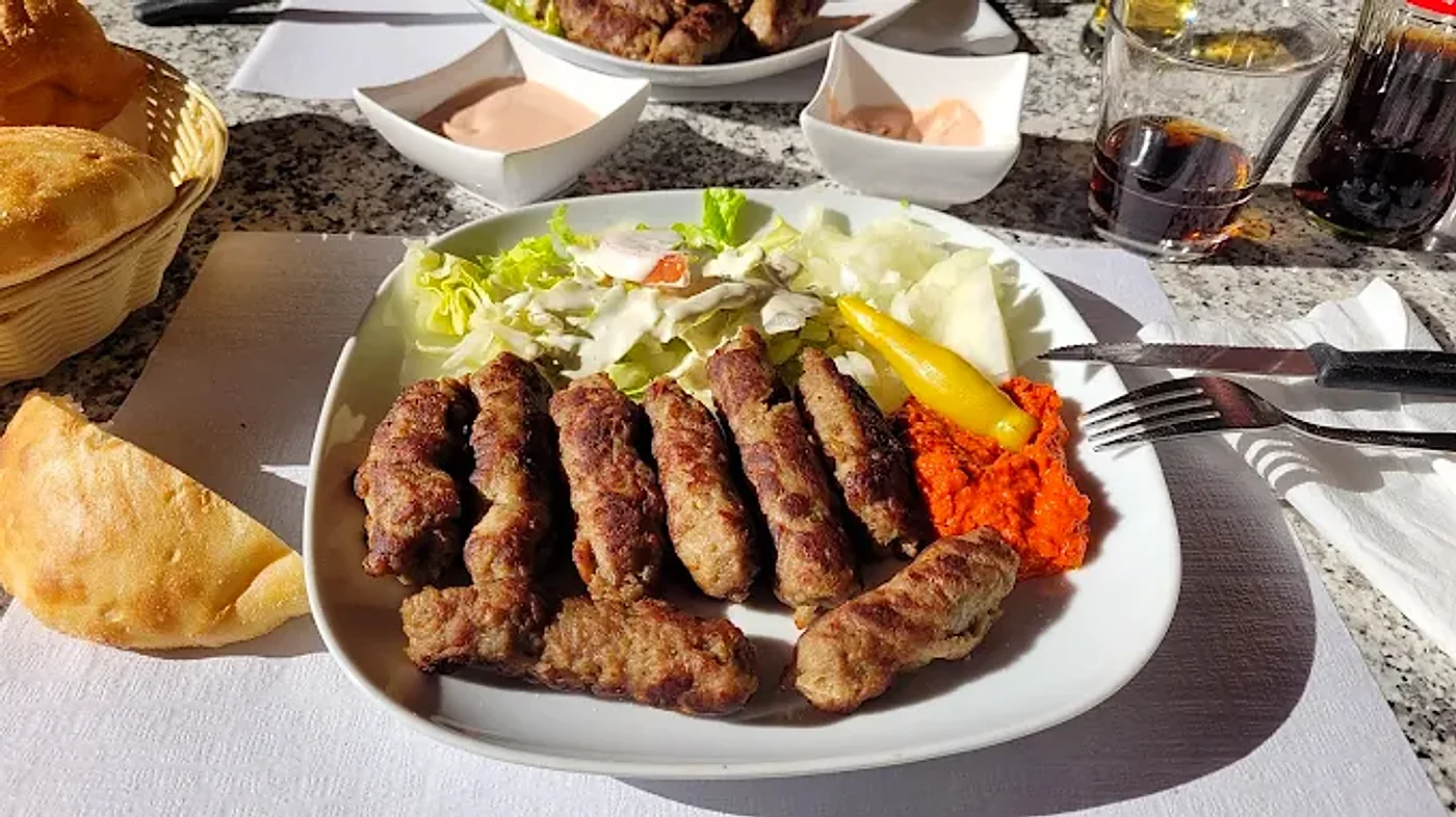 Ćevapi vom Grill mit Salat, Ajvar, Peperoni und Fladenbrot