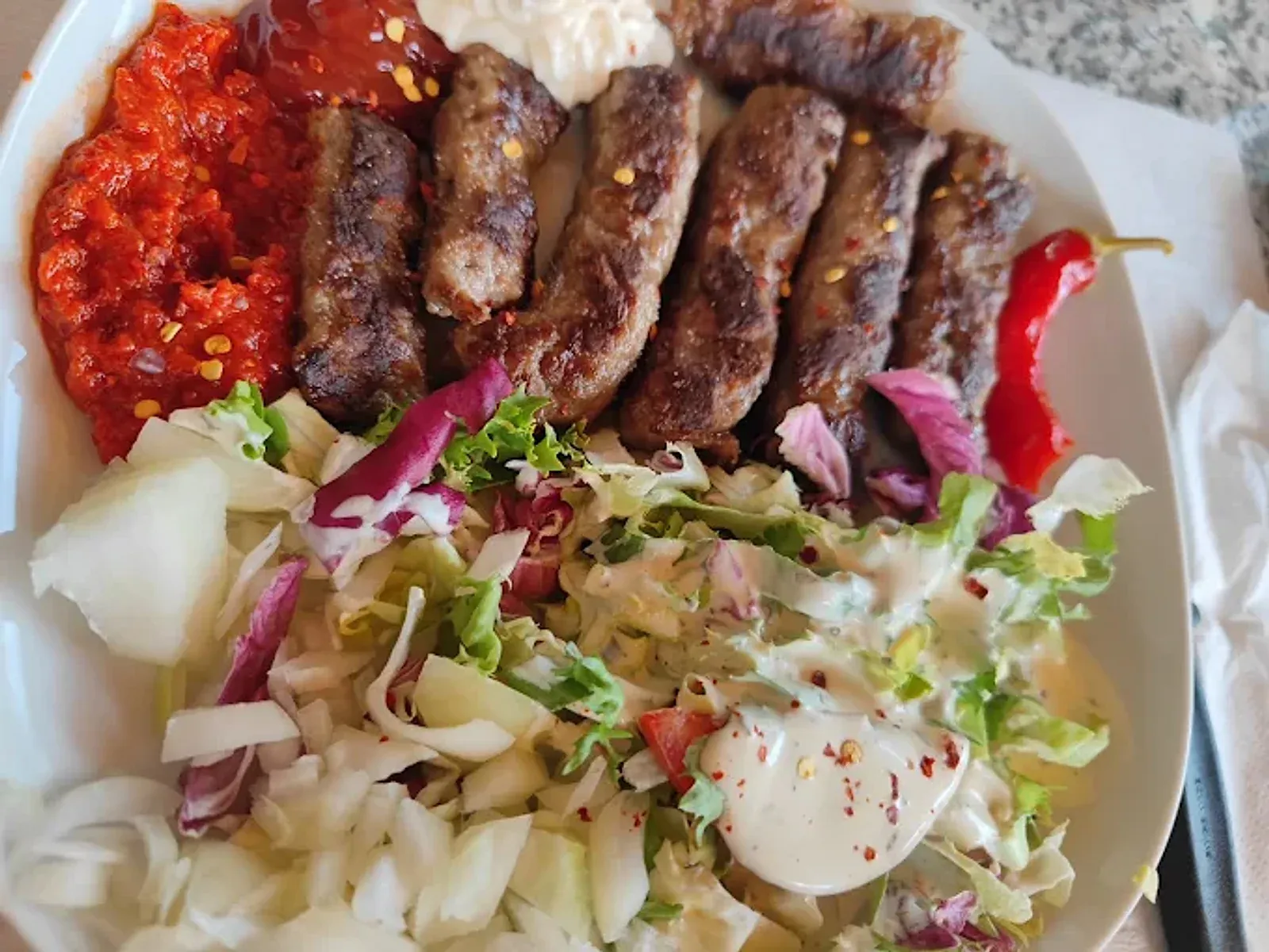 Ćevapi vom Holzkohlegrill mit Ajvar, Salat und Peperoni im Victoria Restaurant Fahrweid